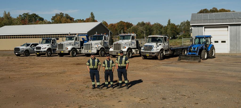 Rob, Jason and Chris standing in the yard in front of the whole Milne's fleet.