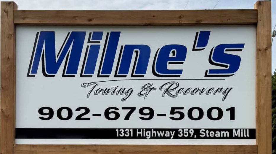 Roadside sign reading Milne's Towing & Recovery, 902-679-5001, 1331 Highway 359, Steam Mill.